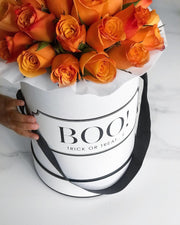 Hermes Orange Roses in a personalised monochrome white hat box with custom Halloween text "Boo! Trick Or Treat". Created by Cartel Flowers the worlds first personalised flowers you can customise and personalise the writting message on the box with anything you like for any occasion. 